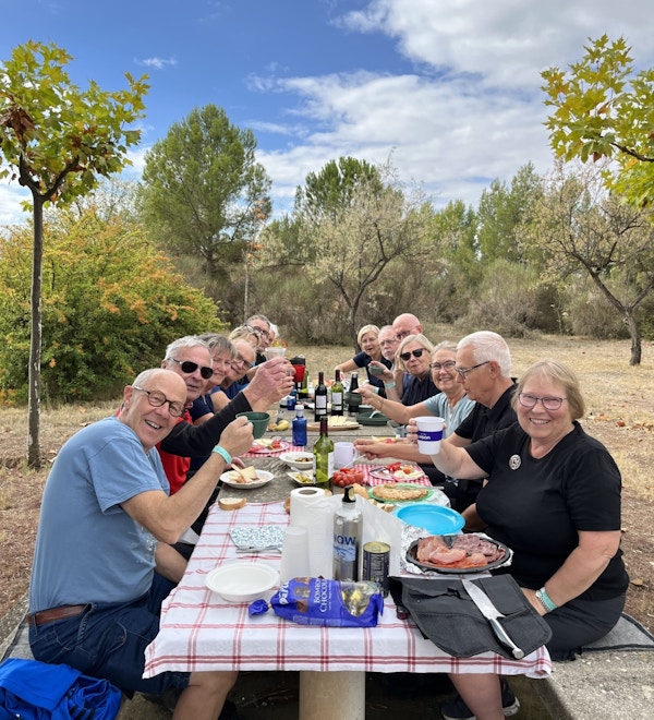 Lunsj stopp hvor gruppen spiser og koser seg med piknikk lunsj  og hvor de sitter på krakker og ved bord