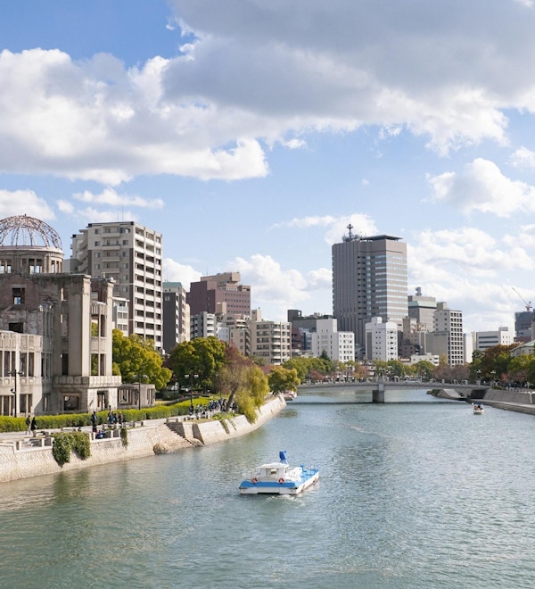 Høstfarger langs bredden av elven Ota i Hiroshima sentrum. Til venstre er den UNESCO-beskyttede Atomic Bomb Dome-bygningen, som lå nær detonasjonsstedet for atombomben som falt 6. august 1945. Bygningen har med hensikt blitt liggende i en ubehandlet tilstand siden 1945.