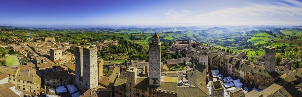 Panoramautsikt over hustakene og de ikoniske steintårnene i San Gimignano, den middelalderske bakketoppsbyen som ligger blant grønne vingårder i hjertet av Toscana, Italia.