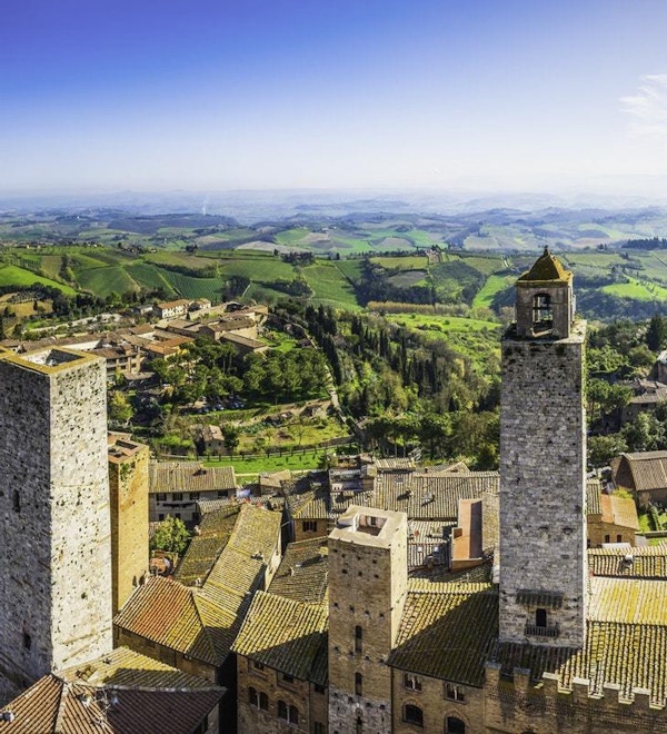 Panoramautsikt over hustakene og de ikoniske steintårnene i San Gimignano, den middelalderske bakketoppsbyen som ligger blant grønne vingårder i hjertet av Toscana, Italia.