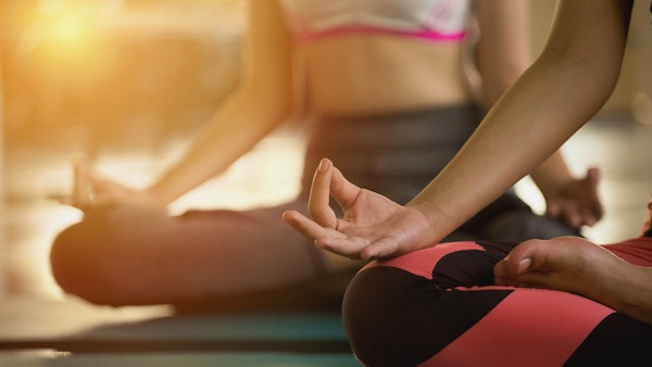 Nærbilde hender av kvinne som gjør yoga og utøver meditasjon.