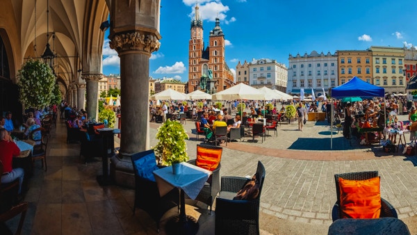 Krakow full av turister som har en kaffepause under buene i Cloth Hall