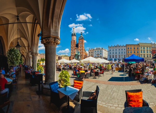 Krakow full av turister som har en kaffepause under buene i Cloth Hall