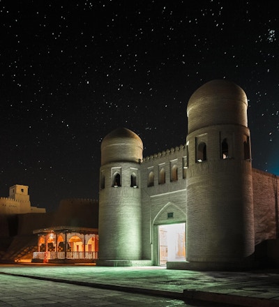 Den vestre porten (Ata Darvoza) til den gamle byen Itchan Kala om natten med stjerner. Khiva, Usbekistan