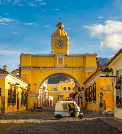 en tuk-tuk-taxi passerer inn fra Santa Archina-buen i Antigua, Guatemala.