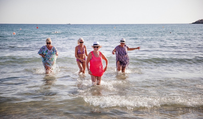 Liten gruppe eldre kvinner som morer seg i havet. Sommerdag på Kypros.
