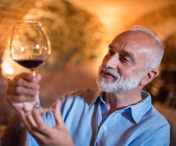 Familieferie i Langhe-regionen, Piemonte, Italia: En mann velger og smaker vin