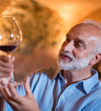 Familieferie i Langhe-regionen, Piemonte, Italia: En mann velger og smaker vin