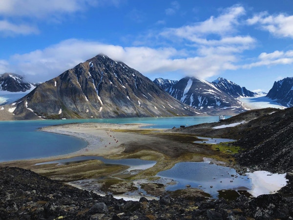 Landskap på Svalbard med fjell, fjord og sandstrand