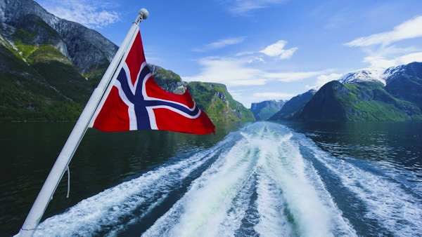 Norsk flagg på baksiden av en ferge som krysser fjordene
