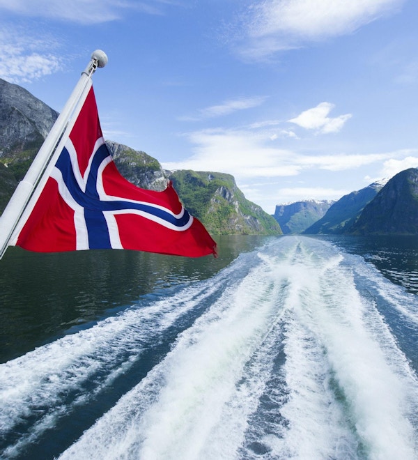 Norsk flagg på baksiden av en ferge som krysser fjordene
