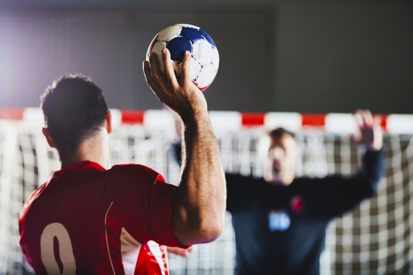 Straffespark. Sett bakfra av håndballspiller som skyter i mål, mens keeper er i bakgrunnen med hendene løftet.