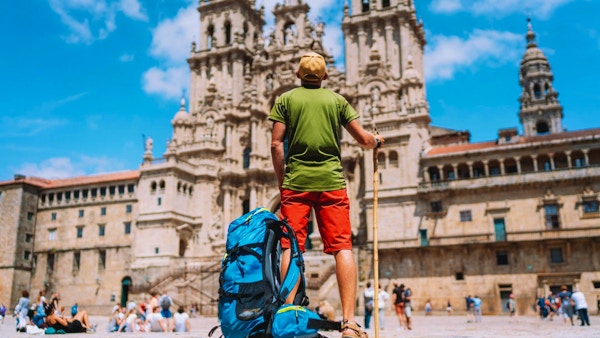 Ung backpacker-pilegrim som står på Obradeiro-plassen (torget) - hovedtorget i Santiago de Compostela.