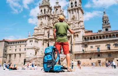 Ung backpacker-pilegrim som står på Obradeiro-plassen (torget) - hovedtorget i Santiago de Compostela.