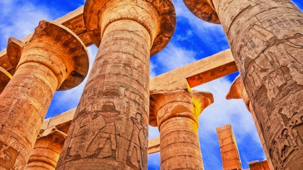 Egyptiske søyker med hieroglyfer fotografert nedenfra mot en blå himmel.