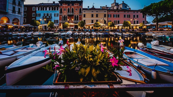 Blå time utsikt over Desenzano del Garda marina med åpne restauranter. Bilde tatt 20. august 2021 i Desenzano del Garda, Brescia-provinsen, Lombardia, Italia.