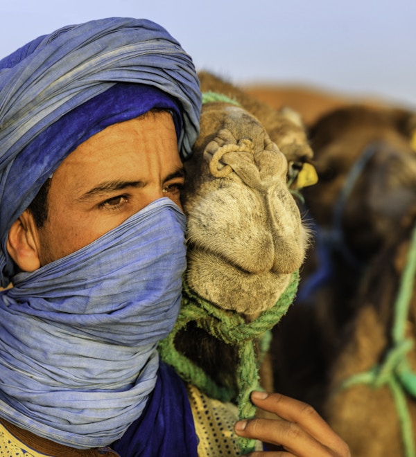 Tuareg med kamel i den vestlige delen av Sahara-ørkenen i Marokko. Sahara-ørkenen er verdens største varme ørken.