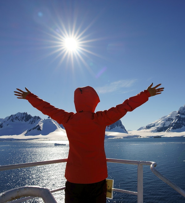 Kvinne som ser på isbreen i Antarktis fra båten