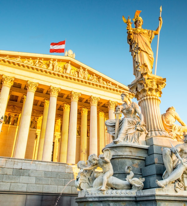 Den østerrikske parlamentsbygningen med statuen Athena i front i Wien ved soloppgangen
