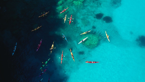 En gruppe kajakkpadlere er samlet på det blå havet utenfor Kefalonia