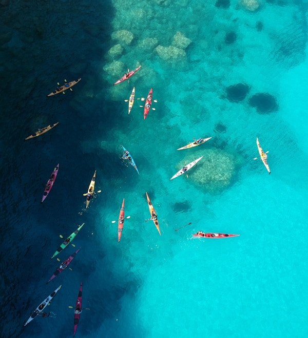 En gruppe kajakkpadlere er samlet på det blå havet utenfor Kefalonia