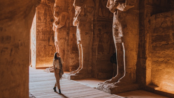 Ung kaukasisk kvinne som går inne i Abu Simbel-templene