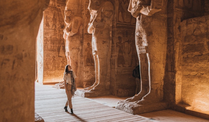 Ung kaukasisk kvinne som går inne i Abu Simbel-templene