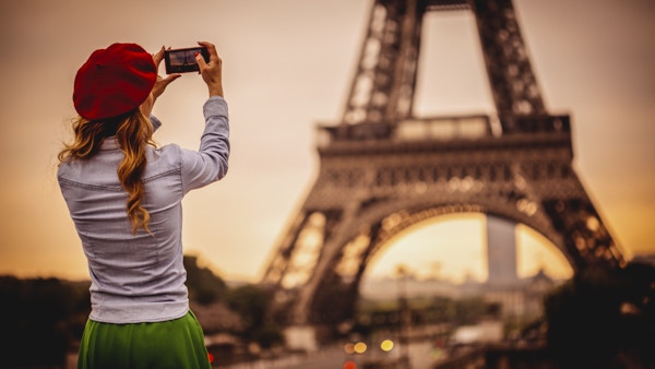 En kvinne som tar bildet av Eiffeltårnet