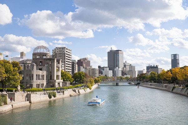 Høstfarger langs bredden av elven Ota i Hiroshima sentrum. Til venstre er den UNESCO-beskyttede Atomic Bomb Dome-bygningen, som lå nær detonasjonsstedet for atombomben som falt 6. august 1945. Bygningen har med hensikt blitt liggende i en ubehandlet tilstand siden 1945.