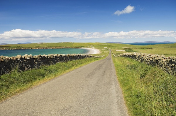 "Veien går mot Sands of Wright på øya South Ronaldsay, Orknøyene, Skottland."