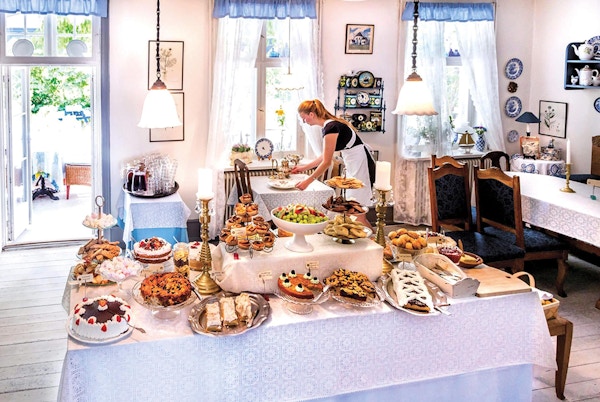 Bord med mange ulike kaker i hyggelig gammeldags cafe
