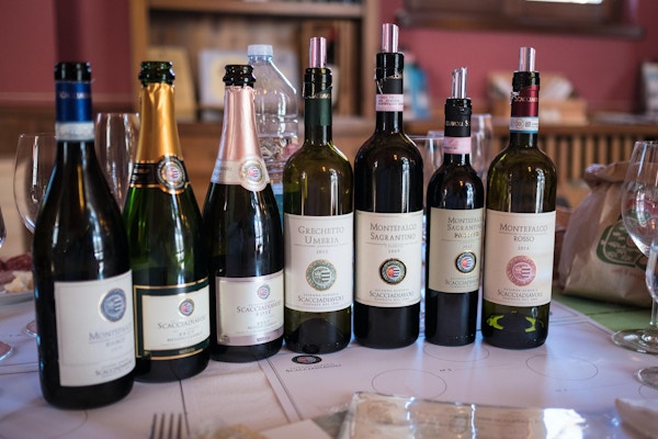 syv flasker vin på et bord