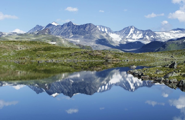 Refleksjon av fjellkjede i et lite hav i Jotunheimen nasjonalpark i Norge.
