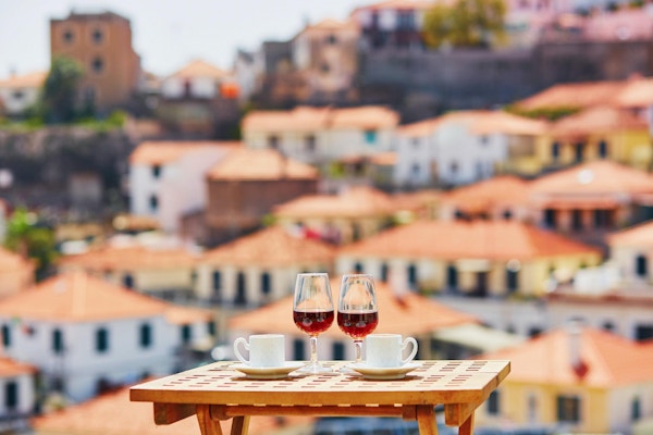To glass Madeira-vin og to kopper fersk espressokaffe på kafé med utsikt til Funchal by, Madeira, Portugal