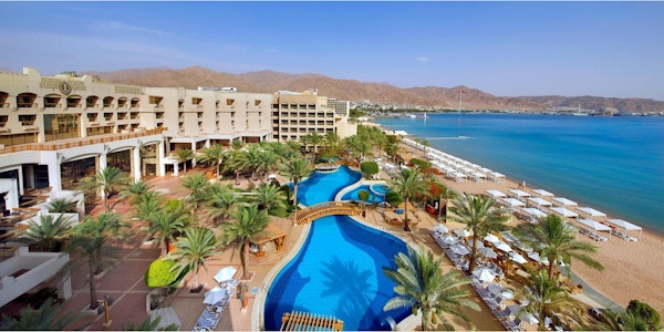 Utsikt over Intercontinental Hotels svømmebasseng og private strand med røde svaberg i bakgrunnen