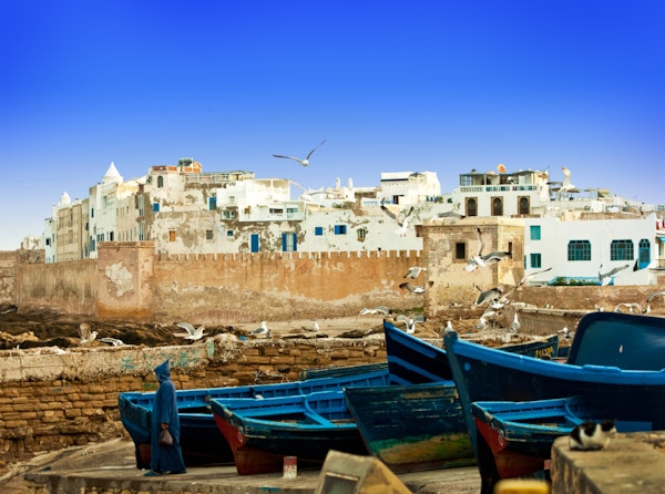 Blå fiskebåter på land ved en havkyst i Essaouira, Marokko
