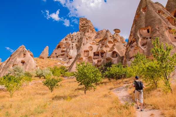 Ryggsekkturist på fottur blant hulesteiner i Cappadocia-området, sentrale Tyrkia.