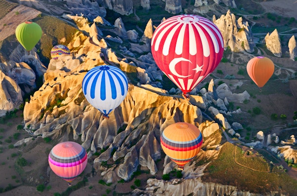 Luftballonger over fjellandskapet i Cappadocia, Goreme nasjonalpark, Tyrkia.