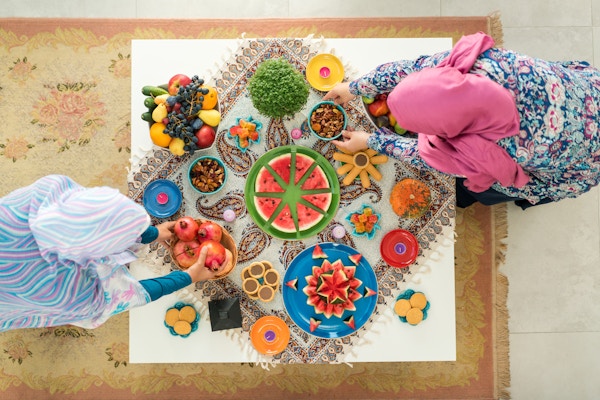 To kvinner tilbereder mat dekorert bord klar for familiesammenkomst