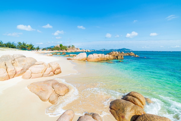 Nydelig tropisk strand turkis gjennomsiktig vann unike steinblokker, Cam Ranh Nha Trang Vietnam sørøstkysten reisemål, ørkenstrand ingen mennesker klarblå himmel