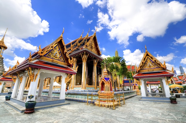 "Grand Palace og Wat Phra Kaew Temple interiør, Bangkok, Thailand. Emerald Buddha-tempelet. Synlig er et av de mange Buddha-templene i interiøret i Grand Palace. Dramatisk skyer med blå himmel og cumulusskyer over Grand Palace. Spesifikk Thai og Buddha Arkitektur.Se flere bilder som dette på: "