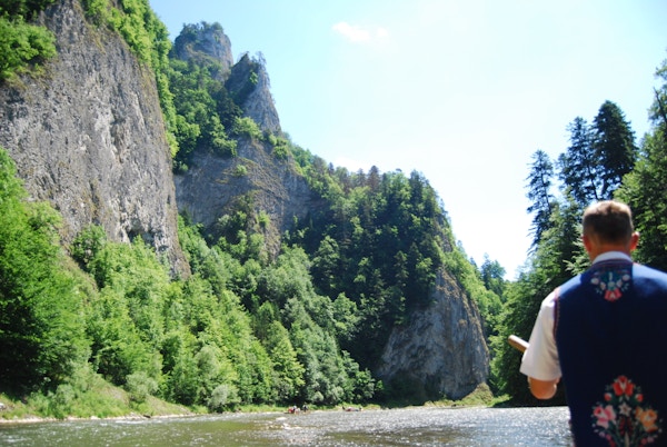 Mann i tradisjonell drakt styrer flåte nedover elv i Slovakia