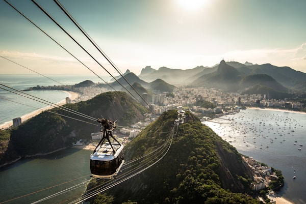 Utsikt over byen Rio de Janeiro fra Sukkertopp-fjellet ved solnedgang med en taubane som nærmer seg.
