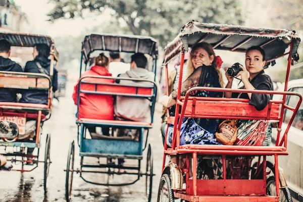 To fotografer som liker en riksja-tur i Old Delhi, India.