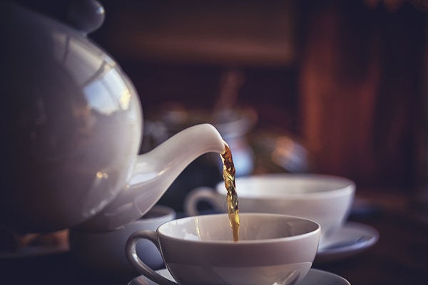 Kopp svart te servert med kjeks