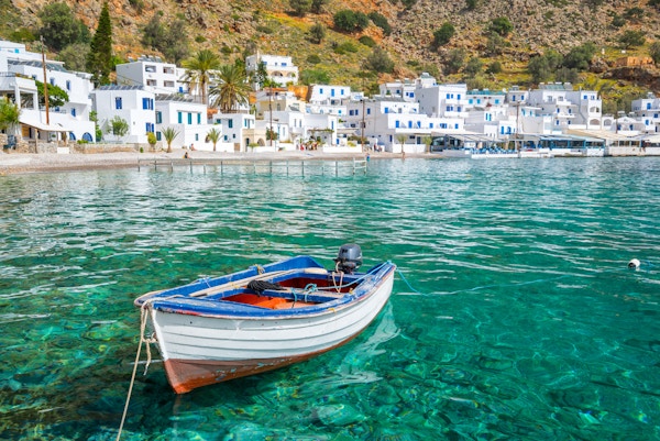 Fiskebåt og den naturskjønne landsbyen Loutro på Kreta, Hellas