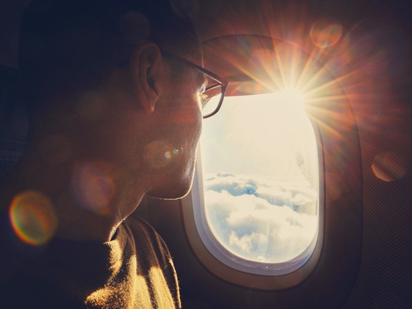 Mann ser ut vinduet på fly