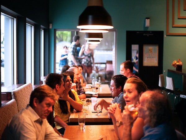 En gruppe mennesker sitter sammen på en restaurant