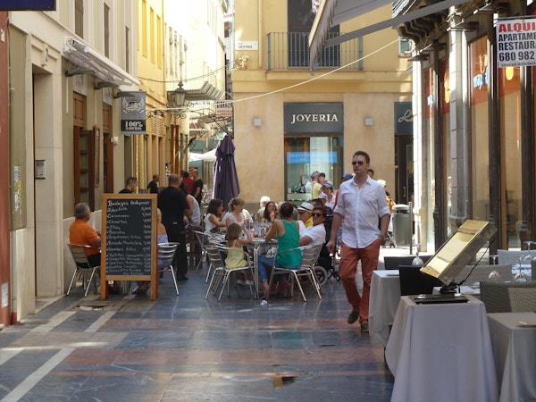 Mennesker sitter på kafe i gamlebyen i Malaga.
