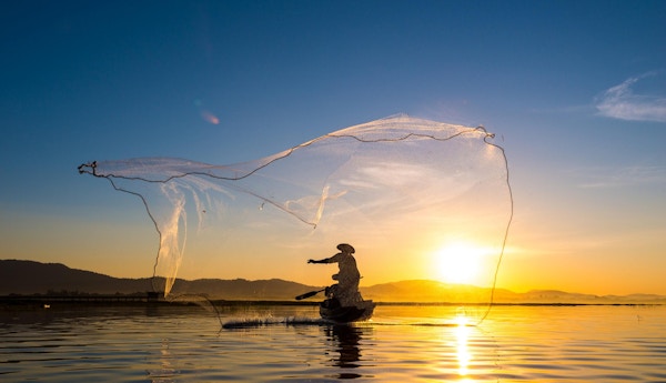 Fisker i aksjon under fiske om morgenen, Vietnam.